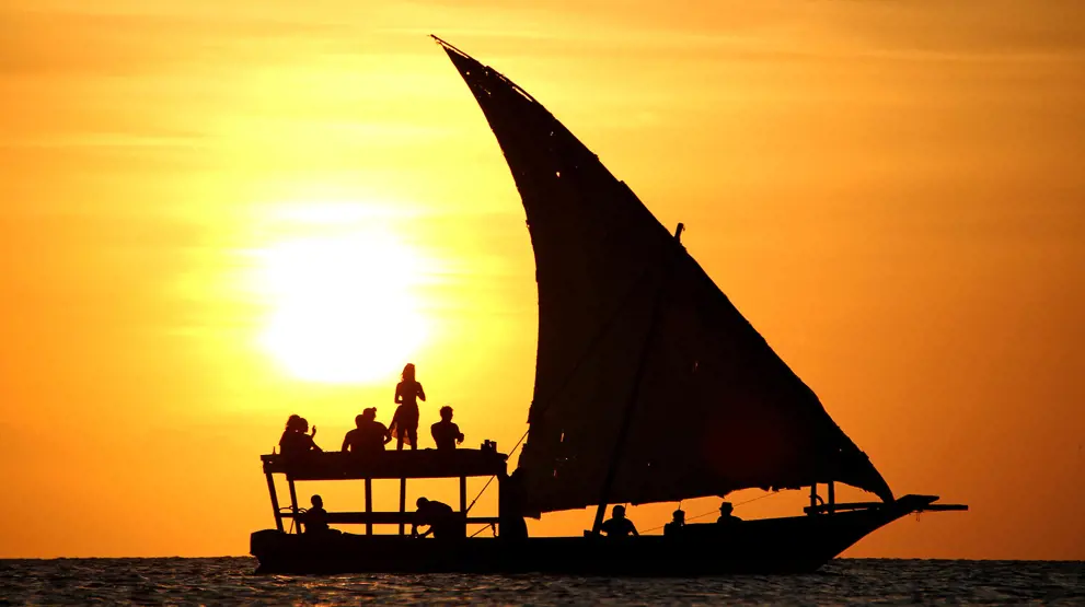 Dhow-båd i flot solnedgang ved Zanzibars kyst.